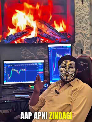 The image shows a person wearing a silver mask with a computer screen showing stock charts to the left and right with a monitor in between. The man is sitting with his right hand open. There is a fireplace in the background.