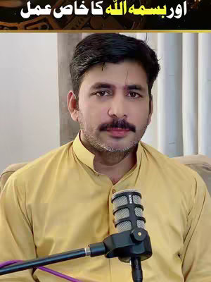 A man in a yellow collared shirt speaking into a microphone. There is text above the man's head in the image. The background is somewhat blurred.
