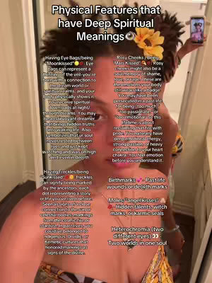 The cover image features a female with brown skin, positioned in a selfie view. She's wearing a top and a yellow flower in her hair. Text overlays describe spiritual meanings of physical features.  A handheld phone, presumably capturing the image, is visible in the upper right corner