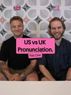 The cover image shows two men smiling, positioned next to each other. Above them are the flags of the United Kingdom and the United States. A pink rectangle in the center of the image displays the text 'US vs UK Pronunciation. Part One'.
