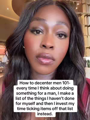The cover image features a close-up shot of a Black, dark-haired woman looking directly at the camera, centered in the frame. She has full lips and a neutral expression, with subtle makeup including blush and eyeshadow. Below her, a white rectangular box contains text in a sans-serif font, describing a strategy for self-prioritization. The background appears to be a blurred indoor setting with hints of gold and neutral tones.