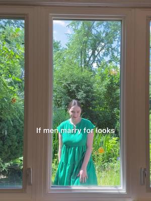 A woman in a green dress stands centered in a large window frame. The window offers a view of lush green foliage. Text overlayed on the image reads, "If men marry for looks".