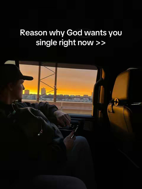 A man looks out the window of a car at a sunset. Text overlay is written in white at the top.