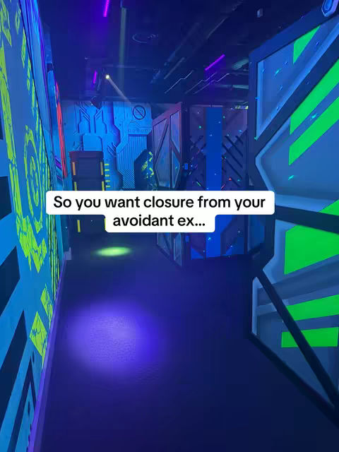 An indoor shot of a laser tag arena, with neon blue and green lighting illuminating walls and structures. A white text overlay reads "So you want closure from your avoidant ex..."