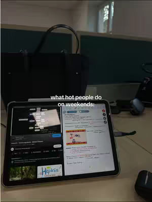 A tablet displaying a split screen with notes on one side and a video on the other. A handbag and desk accessories are in the background.
