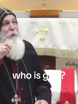 A medium shot of a man with a gray beard and black hat, speaking. Text overlaid, "who is g?"