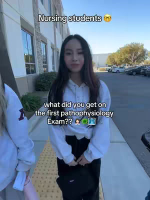 A young woman stands in front of a building, apparently outside a school, with text overlays indicating the video's theme of nursing students and their first pathophysiology exam. She's positioned in the central frame, slightly angled to the left.