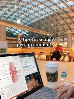 The image shows a laptop open with a medical diagram on the screen, a coffee, a small bottle, and a hand. The background is a blurred cafeteria scene.