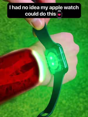 The cover image shows a hand holding a green smartwatch over a red illuminated arm. The background is green.