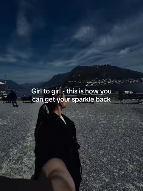 The cover image shows a woman from behind, standing on a paved area, looking toward a mountainous landscape under a cloudy sky. Text overlays the image.