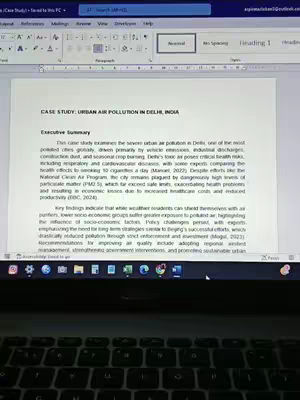 A laptop screen displays a document titled "CASE STUDY: URBAN AIR POLLUTION IN DELHI, INDIA". The executive summary is visible.