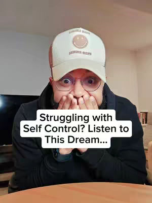 A man with a beard and glasses is covering his mouth with his hands, his eyes wide with apparent surprise or concern. He wears a white baseball cap that has a smiley face and the words "Jasmine Green" embroidered on it. Below him is a white box with the words "Struggling with Self Control? Listen to This Dream..."