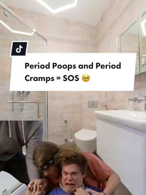 The image features a man being held by another in a bathroom. Overlay text says "Period Poops and Period Cramps = SOS". The room includes a toilet, sink, and mirror.