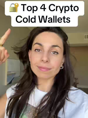 A woman with dark hair is pointing upward. She has a somewhat inquisitive expression. Above her head is a white banner with black text that says "Top 4 Crypto Cold Wallets," and there is a small icon of a padlock with a gold key.