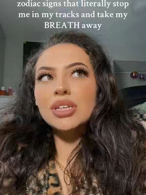 A woman with dark hair and makeup looks up with an expression of thought in a close-up shot. The background is blurry but appears to be a room. Text overlays the image.