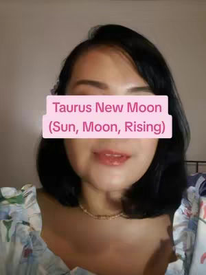 A medium close-up shot features a woman with dark hair and a floral-patterned top. A pink rectangle obscures her eyes, text that reads (Taurus New Moon (Sun, Moon, Rising)) is visible. The background is blurred, suggesting an indoor setting.
