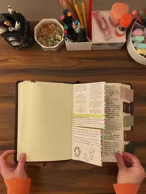 The cover image shows a top-down view of a wooden desk with a Bible opened, with notes and tabs. Stationery items like pens and highlighters are visible in the background.