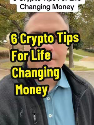 A medium shot of a man in a blue dress shirt and a partially visible black jacket. Overlayed on the shot is a yellow and black graphic with the text: "6 Crypto Tips For Life Changing Money". The background shows a blurred outdoor setting with trees.