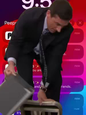 The cover image features a man in a black suit, similar to Michael Scott from The Office, kneeling beside a chair in what appears to be an office setting. Text bubbles with the word 'now' appear to the right side of the screen, set against a gradient background of red, purple, and blue. The man is reaching towards the chair.