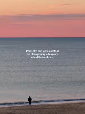 The image captures a serene beach scene at dusk. The sky transitions from a bright orange at the horizon to a deeper pink at the top, suggesting sunset. Below, a calm ocean stretches to the horizon. A person, silhouetted, stands on the sandy beach, facing the water, adding a sense of loneliness and contemplation. Text overlayed on the image reads a motivational quote.