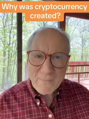 A man in a red checked shirt and glasses is centered in the frame. Behind him is a view of trees and a deck visible through a window. An orange text box at the top says, "Why was cryptocurrency created?"