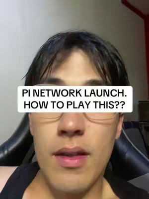 A man with glasses is centered in the frame, a text overlay covers the top center portion of the image that says "PI NETWORK LAUNCH. HOW TO PLAY THIS??". He appears to be in his late 20s or early 30s, with short, dark hair and a slight smile. The background is blurred, but appears to be a neutral color, with a dark gaming chair or office chair in the background.