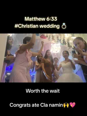 The cover image shows a wedding scene with many people. In the foreground, several women are dancing and celebrating. The background shows a decorated hall with lights and garlands. Text overlays include bible verse and wedding-related hashtags.