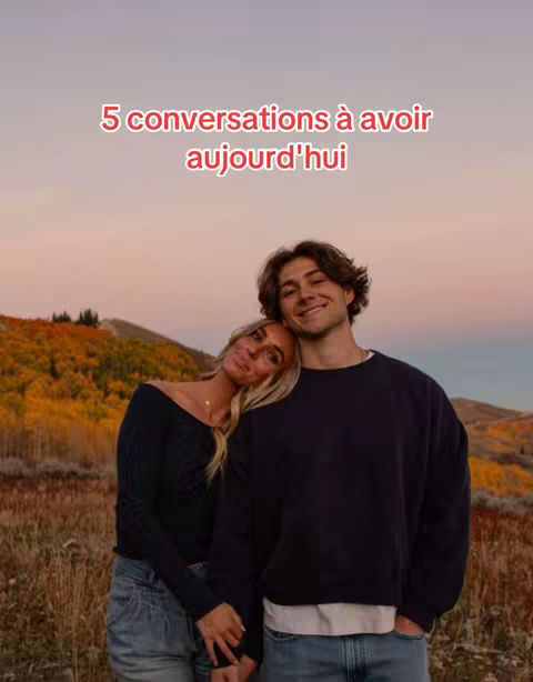 A young couple stands close together in a field with a backdrop of trees and a sunset. The woman leans her head on the man's shoulder, both smiling at the camera. Text overlays at the top read '5 conversations to have today' in red.