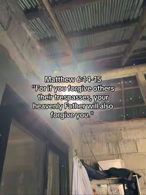 The image shows a low-angle view looking upwards towards a corrugated metal ceiling with the sky partially visible. The lighting is diffused, casting shadows across the uneven surfaces. Overlayed on the image is a quote from Matthew 6:14-15, presented in white text.