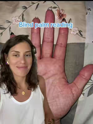 A woman stands to the left of a large hand, showing the palm. Text in a blue bubble reads, "Blind palm reading". The background incorporates a floral pattern on a bedspread.