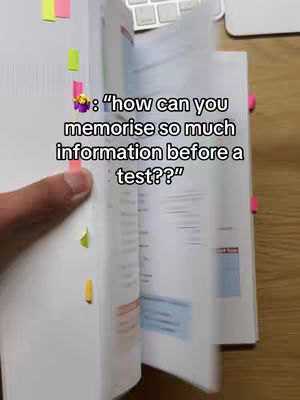 A hand holding open a textbook with notes and colored tabs. A text overlay asks a question about memorization.