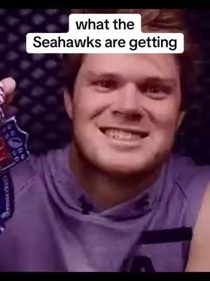 The image is a close-up of a man smiling, with text overlaid on the image. The man has fair skin and short, light-brown hair. He appears to be holding something in his left hand, with part of a logo visible. The background is a blurred gradient of purplish colors. The text box is white, with black text.