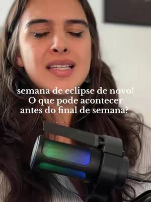 A woman with long brown hair is shown from the chest up, angled slightly off-center. She is facing the camera with her eyes closed and mouth slightly open, as if speaking or singing. She has a microphone positioned close to her mouth. Text appears in a sans-serif font overlaying the image.