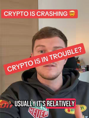 The cover image features a man in a dark hoodie viewed from the chest up. Overlayed with text, the top reads 'CRYPTO IS CRASHING' above his head in a red box, a graphic of a concerned face emoji to the right. A large, red, slanted rectangle blocks his eyes with the words 'CRYPTO IS IN TROUBLE?' printed on it. At the bottom a white box with the text reads 'USUALLY ITS RELATIVELY' and the background implies a well-lit interior.