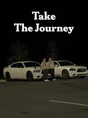The cover image features a nighttime scene with two white Dodge Charger cars parked side-by-side. Two men are standing between the cars. Above them, the text 'Take The Journey' is displayed in a bold, white font.