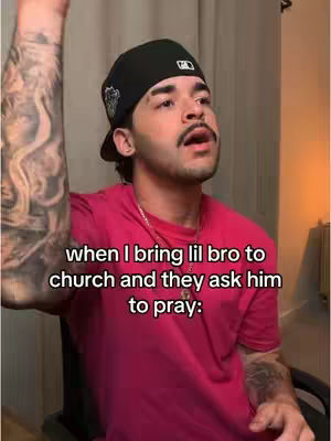 A man wearing a black cap and a pink shirt is in a room with beige walls and a neutral backdrop. Text overlay describes the scene.