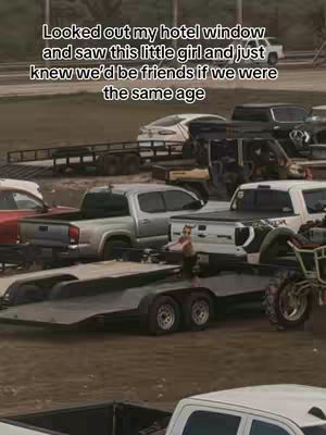 The image shows a parking lot filled with trucks and trailers. In the foreground, a small child is standing on a trailer. Above, text in white font overlays the image.