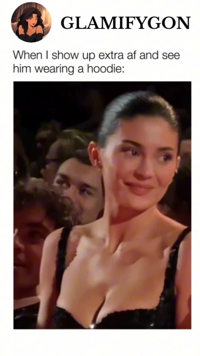 A woman in a sequined black dress looks to the side with a slight smile. Other people are in the background, out of focus. The overall composition is a still from a movie scene or similar.