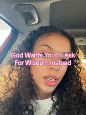 A selfie-style video from inside a car features a young woman with curly hair and a direct gaze. Text overlayed on the image reads, "God Wants You To Ask For Wisdom Instead."