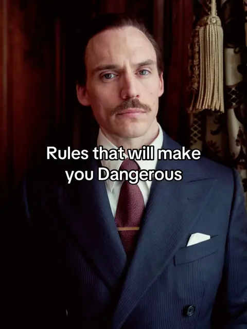A man in a suit with text overlayed. The man has a mustache, is wearing a dark suit, a white shirt, and a red tie. The text overlay says, 'Rules that will make you Dangerous'.