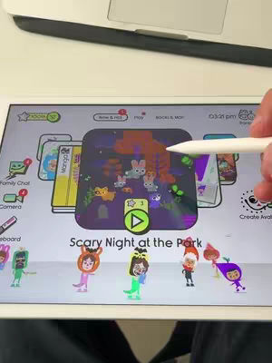 The cover image showcases a tablet displaying a children's app with a Halloween theme. The app's interface features colorful cartoon characters and a central game screen depicting a 'Scary Night at the Park' scene. A hand is holding the Apple Pencil and pointing at the screen.