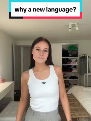 The cover image features a young woman in a white tank top and grey pants posing in what looks like a bedroom. The text overlay at the top, set in bold white letters against a rectangle of black and a thin red line, posing the question "why a new language?" The composition appears well-lit, casual, with a clear focus on the woman. The background is simple, with a white wall and a bed visible.