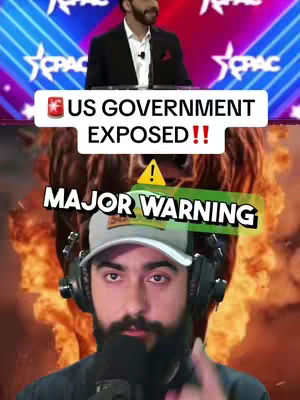 The cover image is a collage with multiple layers. The background features a blurred image of a presentation stage. In the middle layer is a large, blurred image of a bear. Overlaid on top of the bear is a text banner that reads \"MAJOR WARNING\". At the bottom, there is a man wearing a baseball cap over his head and headphones. He has a beard and is staring at the camera. A rectangle is positioned near the top of the image indicating the text \"US GOVERNMENT EXPOSED!!\".