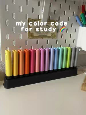 A photo of a collection of colorful highlighters neatly arranged. The highlighters are displayed in a black organizer on a white surface, against a background that appears to be a white pegboard with a framed object. The text overlayed on the image suggests that the image is related to study. The overall aesthetic is clean and organized, with the rainbow of colors being the central visual focus.