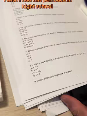A stack of white papers with mathematical questions, a hand at the bottom right corner, and overlay text at the top of the image.