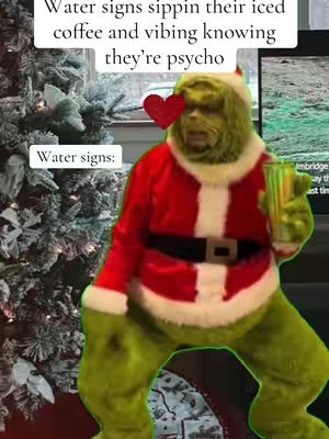 The cover image features the character Grinch dressed as Santa Claus, holding a beverage, likely coffee. The Grinch is positioned in front of a Christmas tree. Text overlays state "Water signs sippin their iced coffee and vibing knowing they're psycho" and "Water signs:" with a heart emoji. The background includes a blurred image of a TV or display.