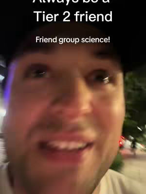 A man in a black cap is shown in a close-up, looking up at the camera with a slight smile, set against a dimly lit outdoor setting. The image is dominated by his face, with overlayed text at the top and bottom.