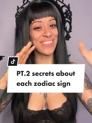 The cover image shows a woman with long black hair, wearing a black top, and a black headpiece. Overlayed on the image is a white box with the text 'PT.2 secrets about each zodiac sign.' The woman is smiling and gesturing with her hands.
