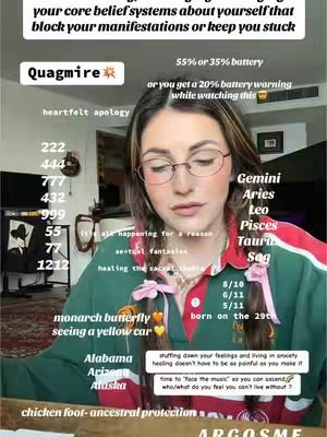A woman with glasses is centered, looking slightly to the right. Various text overlays and graphics are present, including zodiac signs, numbers, and quotes, suggesting a tarot or astrology theme. She wears a green and red collared shirt. The background is a room with blurred elements.