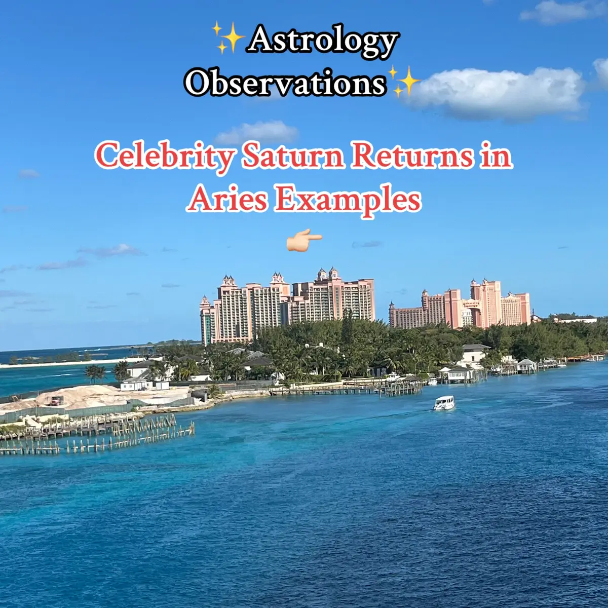 An aerial view of a tropical scene with blue water, buildings, and text overlayed. The water is a brilliant turquoise, transitioning to a deeper blue further out. In the mid-ground, a large pink and white hotel complex with multiple towers and architectural details dominates the horizon. Palm trees and other vegetation separate the buildings. The sky is a clear, light blue scattered with a few fluffy white clouds. The text overlay is in black and red, with a pointing hand emoji. The overall impression is bright, sunny.